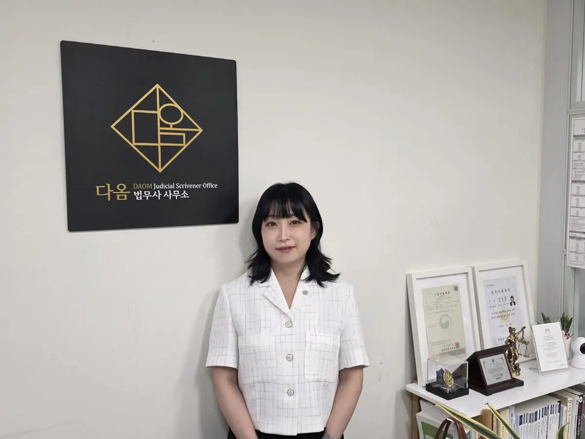 다옴법무사사무소 로고가 걸린 사무실 벽 앞의 모습