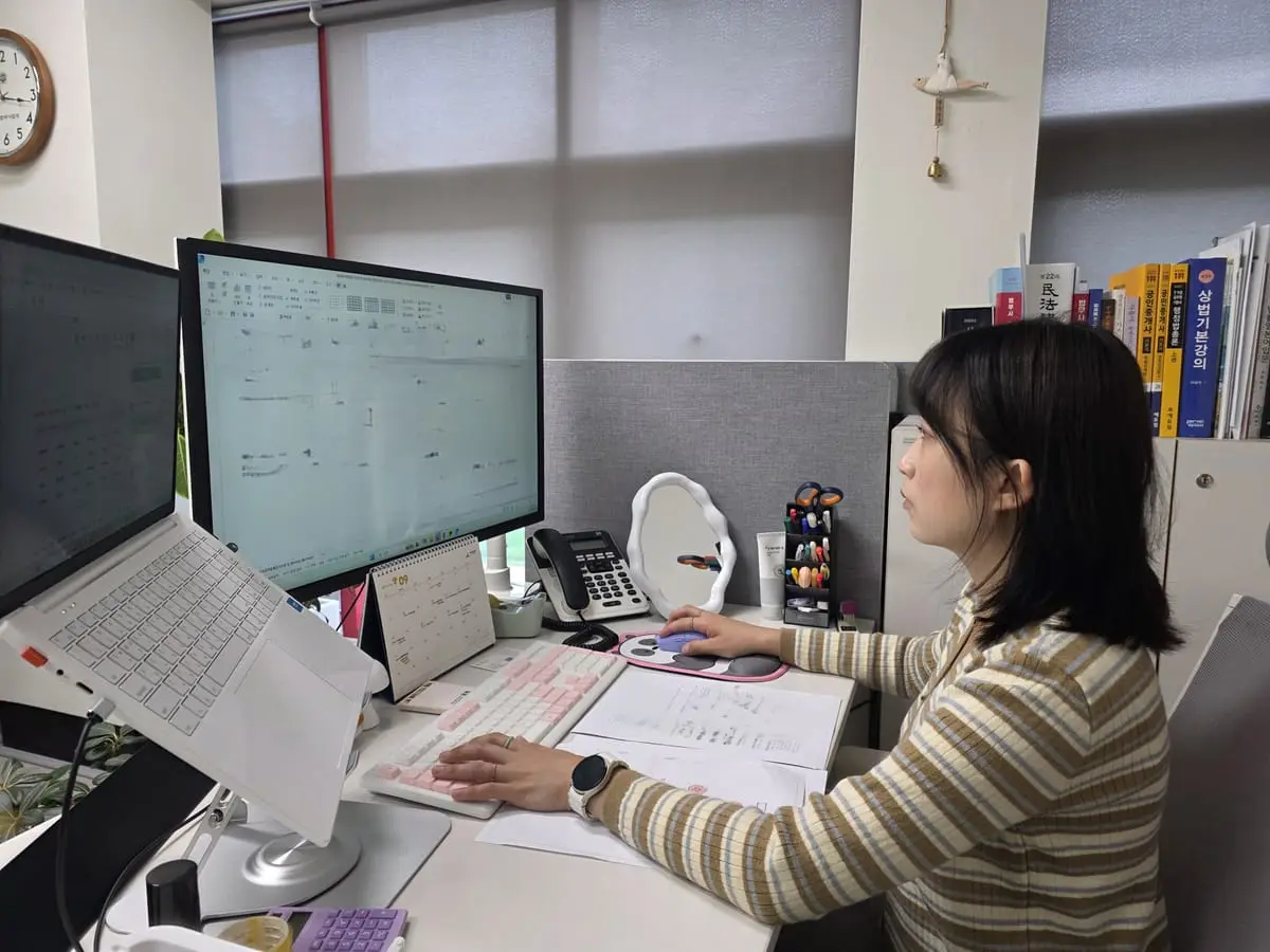 두 대의 모니터를 보며 서류 내용을 입력하는 모습